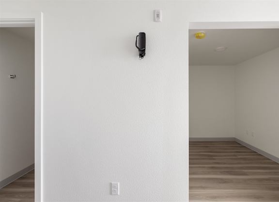 A black security camera is mounted on a white wall at Nook at Northaven Apartments, Seattle, WA, 98125