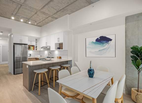 A modern kitchen with a dining table and chairs.