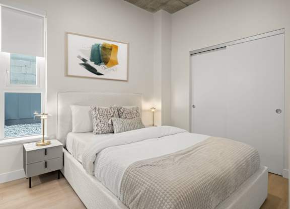 A bedroom with a large bed and a painting above it.