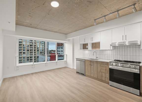 A kitchen with a stove top oven and a window.