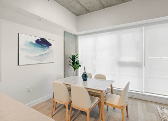 A dining room with a table and chairs.