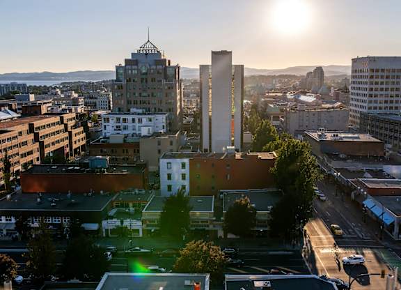 A cityscape with buildings and a sunset in the background.