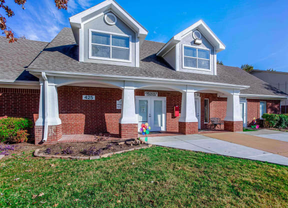 the front of a brick house with a sidewalk in front of it