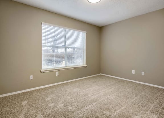 an empty bedroom with a large window