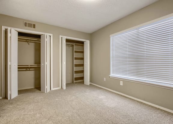 a bedroom with a large window and a closet