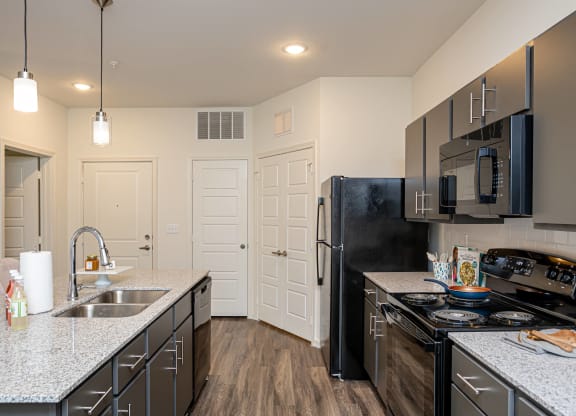 a kitchen with black appliances and granite counter tops