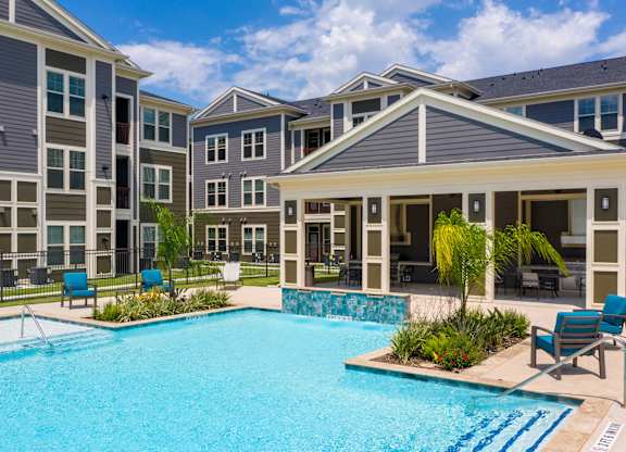a swimming pool with an apartment building in the background
