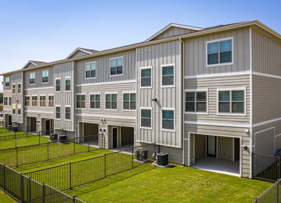 an image of an apartment building with a grassy yard