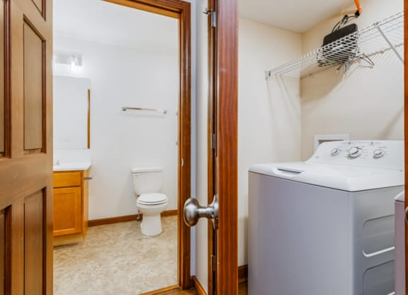 a laundry room with a washer and dryer and a bathroom with a toilet