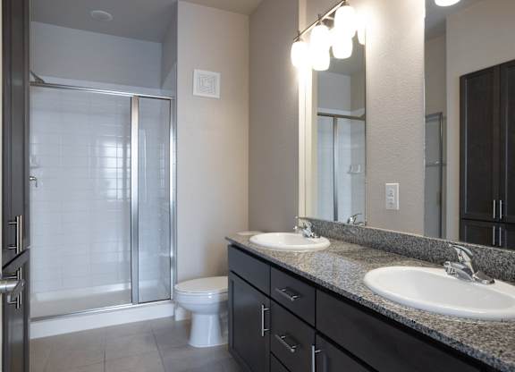 a bathroom with two sinks and a shower and a toilet