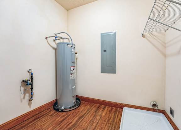 a room with a water heater and a door in the corner