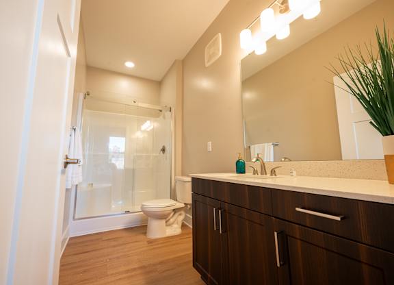 A bathroom with a toilet, sink, and mirror.