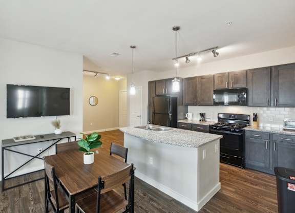A modern kitchen with a dining table and chairs.