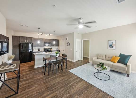 A modern living room with a kitchen in the background.