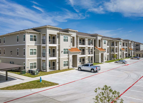 an apartment building with a car parked in a parking lot