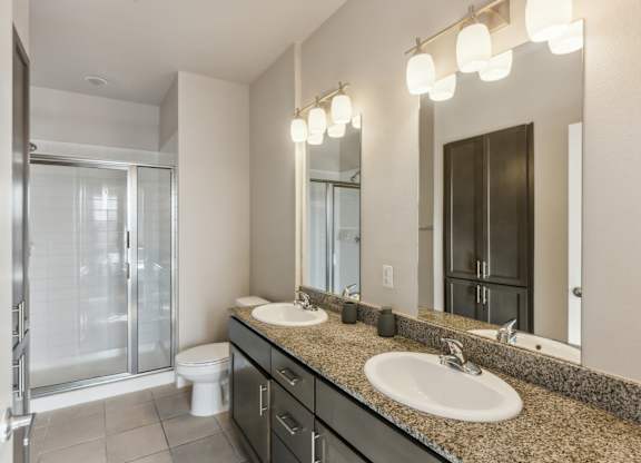 A bathroom with a toilet, sink, and mirror.