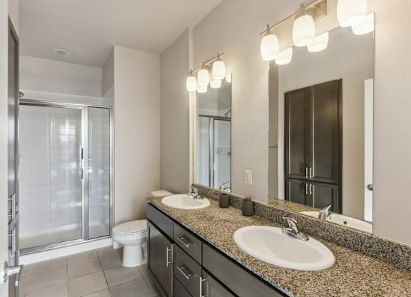 A bathroom with a toilet, sink, and mirror.