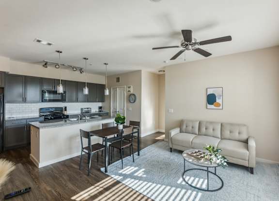 A modern kitchen with a dining table and a couch in the living room.
