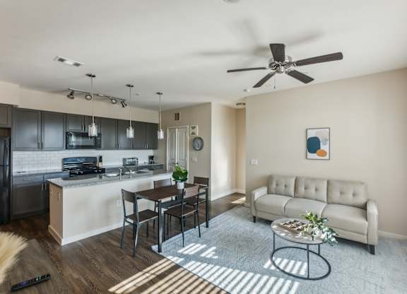 A modern kitchen with a dining table and a couch in the living room.