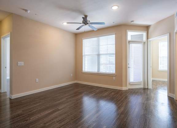 A room with a ceiling fan and wooden floors.