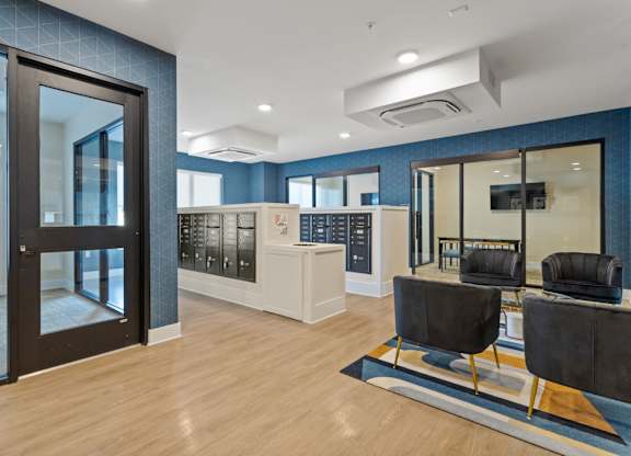 A modern office lobby with black chairs and a wooden floor.