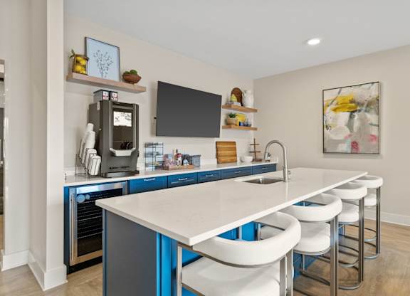 A modern kitchen with blue cabinets and white countertops.
