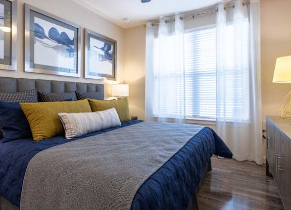 a bedroom with a bed and windows with blinds