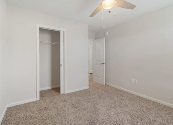 a bedroom with a closet and a ceiling fan
