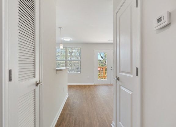 a hallway with white doors and a door to a living room with a door open