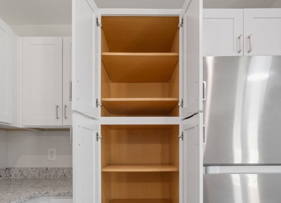 a kitchen with white cabinets and stainless steel appliances and an open refrigerator