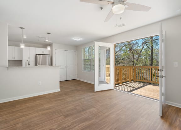 an open living room and kitchen with a sliding glass door to a balcony