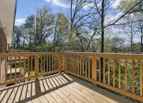 the deck has a view of the backyard and the trees