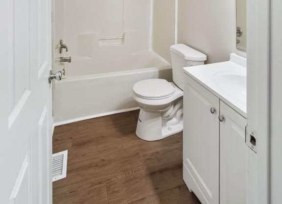 A white bathroom with a toilet, sink, and bathtub.
