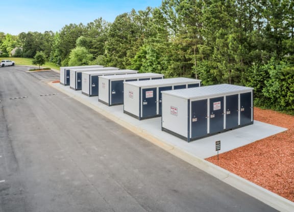 a row of porta potties sit on the side of a road