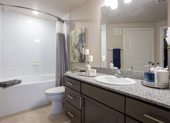 A bathroom with a toilet, sink, and a mirror.