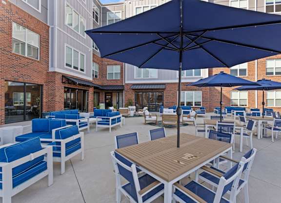 A patio with blue chairs and tables.