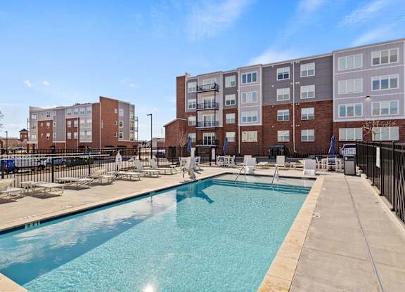 A swimming pool in front of apartment buildings.