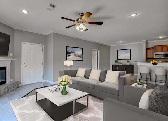 A modern living room with a fireplace and a grey sofa.