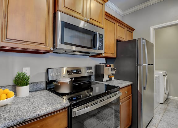 A kitchen with a stove, microwave, and refrigerator.