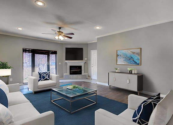 A living room with a white couch, a glass coffee table, and a painting on the wall.