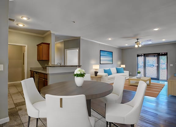 A modern dining room with a round table and white chairs.