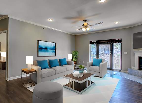 A modern living room with a white sofa, a coffee table, and a ceiling fan.
