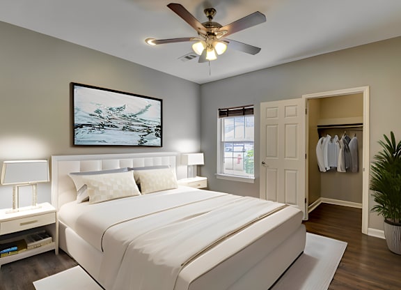 A bedroom with a large bed and a ceiling fan.