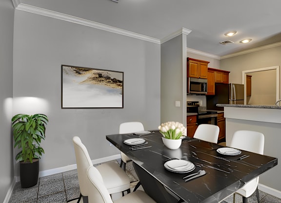 A dining room with a black table and white chairs.