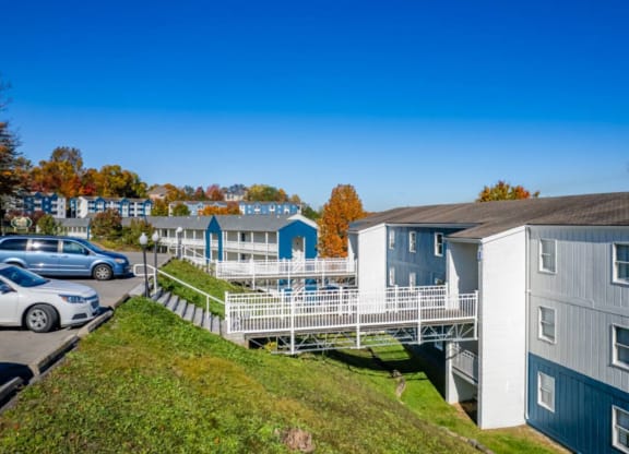 a row of houses with a deck and cars parked in a parking lot