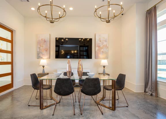 a dining room with a glass table and chairs