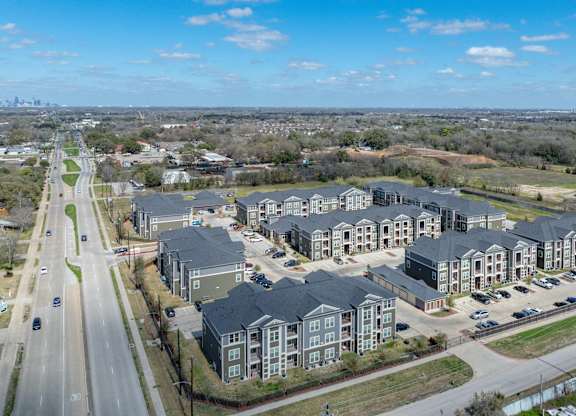 an aerial view of a group of houses next to a highway