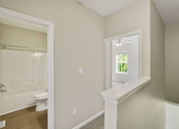 A white bathroom with a window seat and a window.