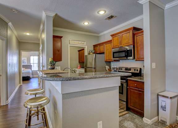 A kitchen with a white counter top and wooden cabinets.