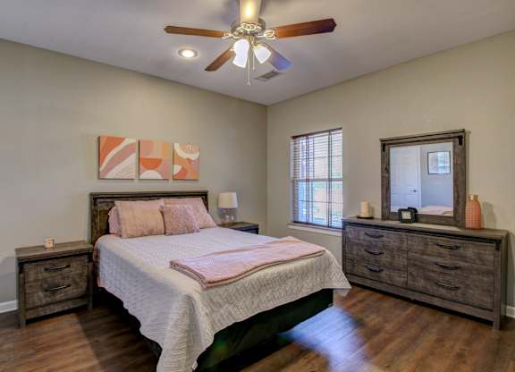 A bedroom with a bed, dresser, and mirror.